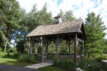 Préau rustique grisé avec une couverture en bardeau de bois